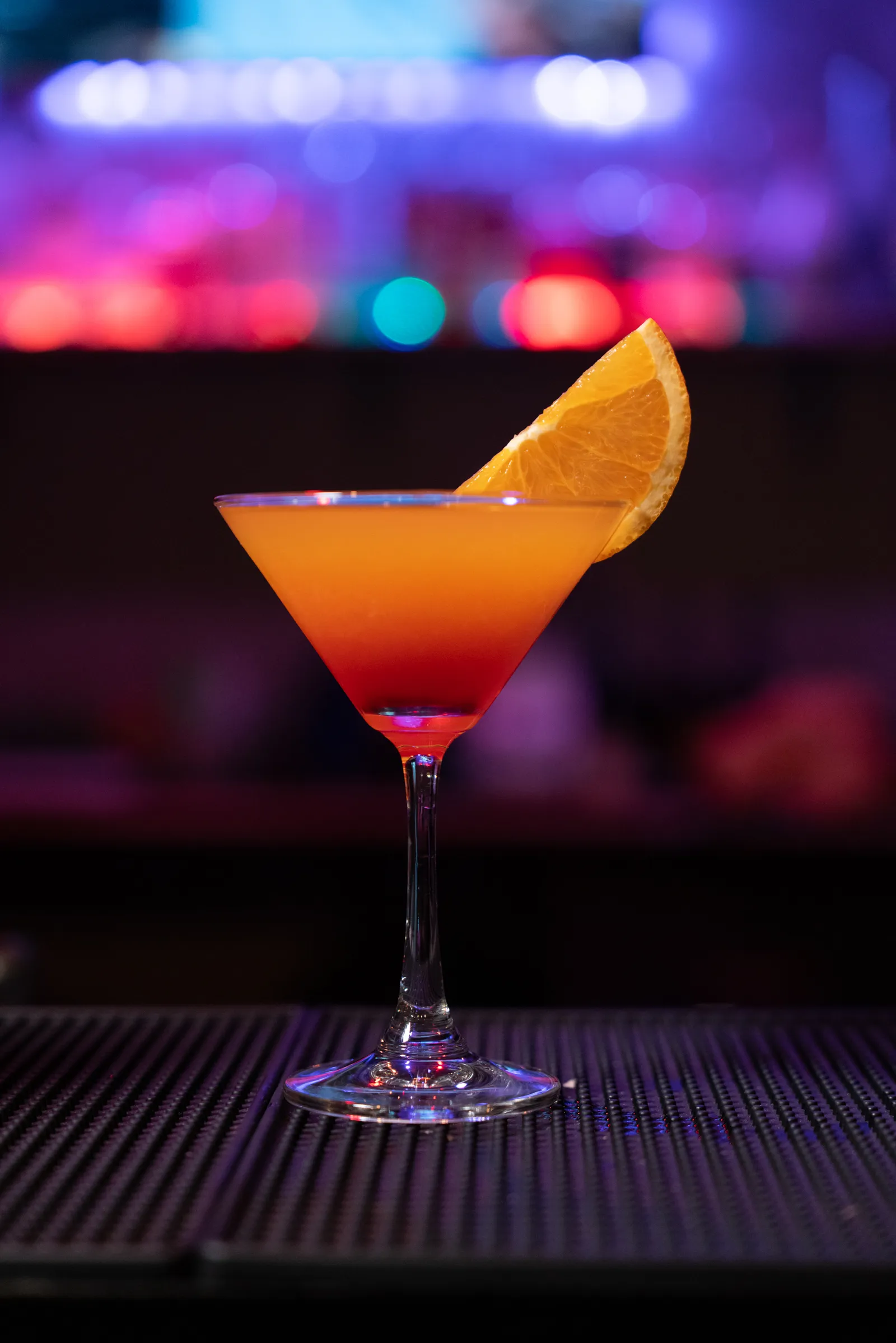 Orange cocktail in a martini glass at the bar