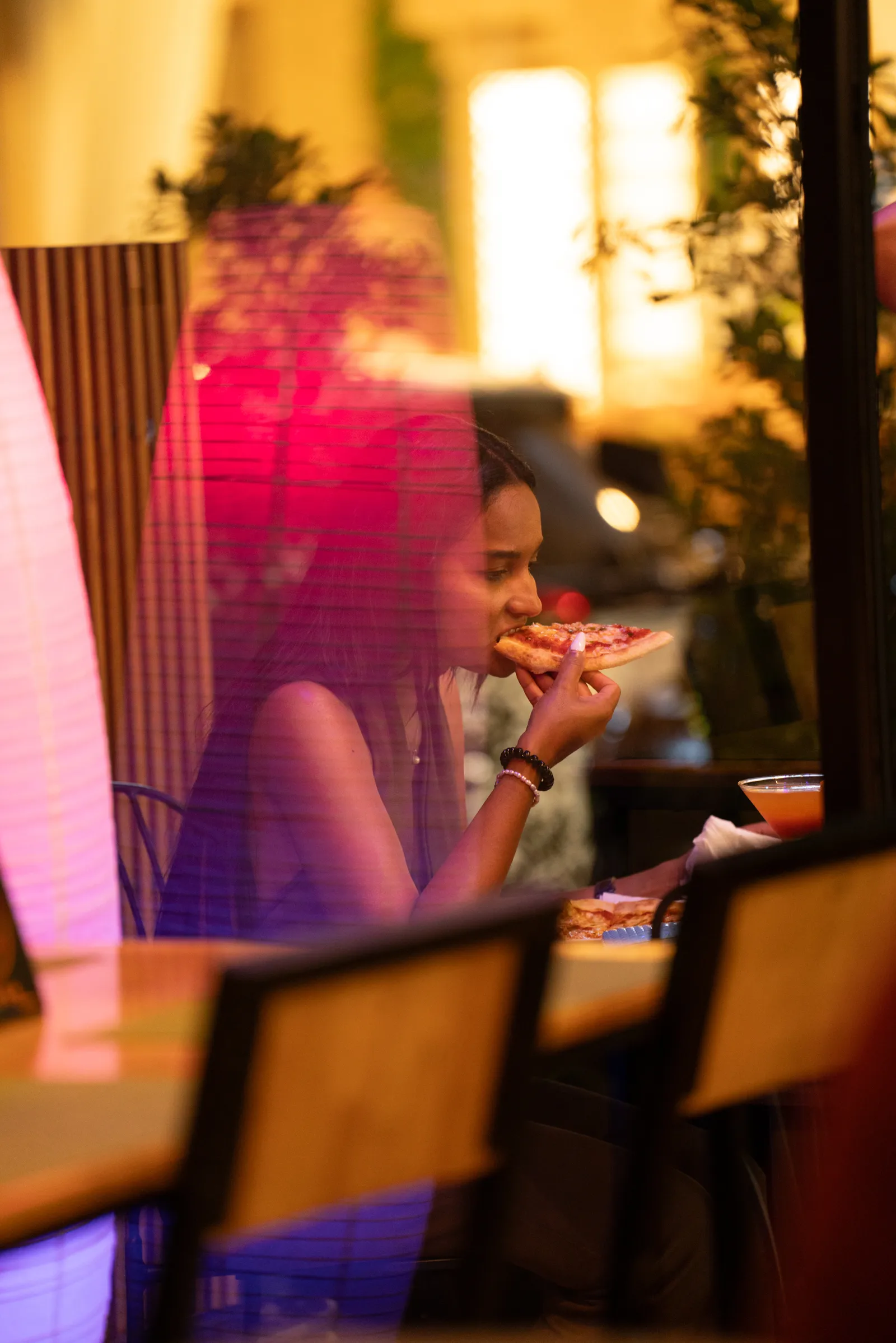 A guest enjoying a slice of pizza under warm lights